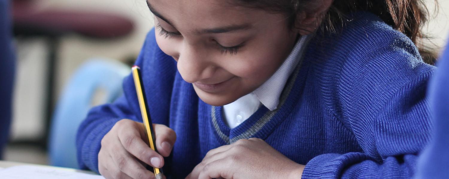 Student writing on paper